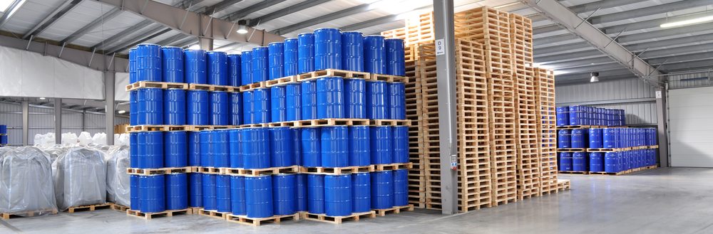 Blue drums stacked on pallets inside a warehouse