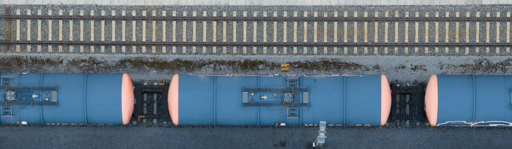 Overhead view of blue rail tank cars beside railway tracks